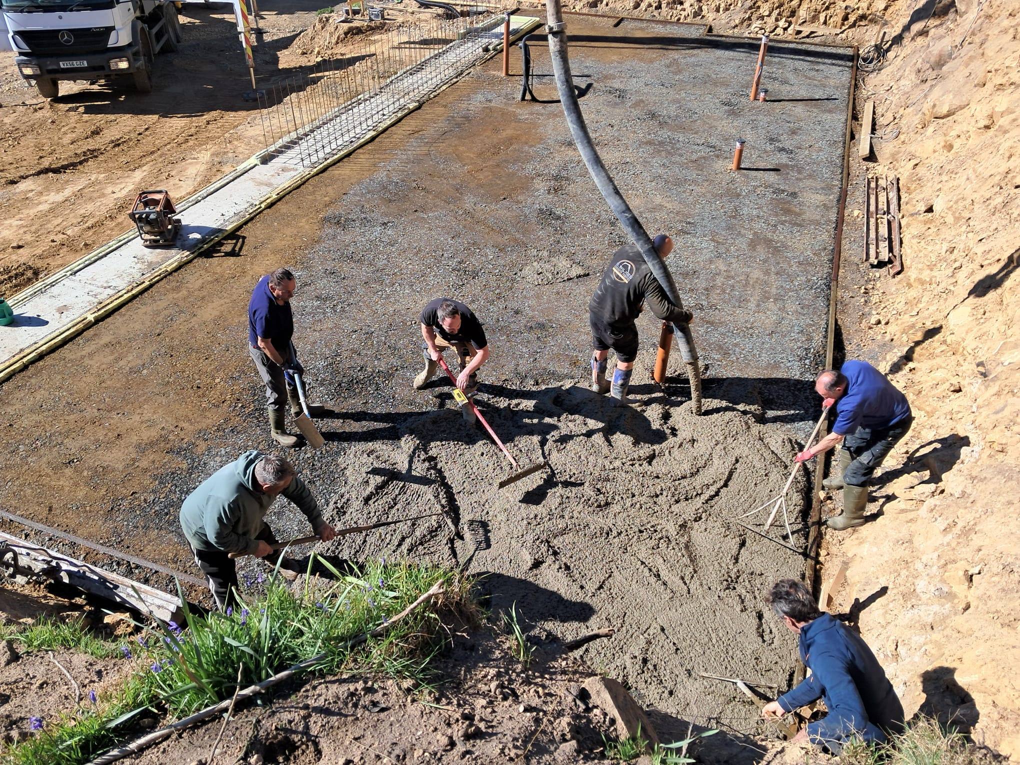 Crew hand finishing a freshly poured concrete slab