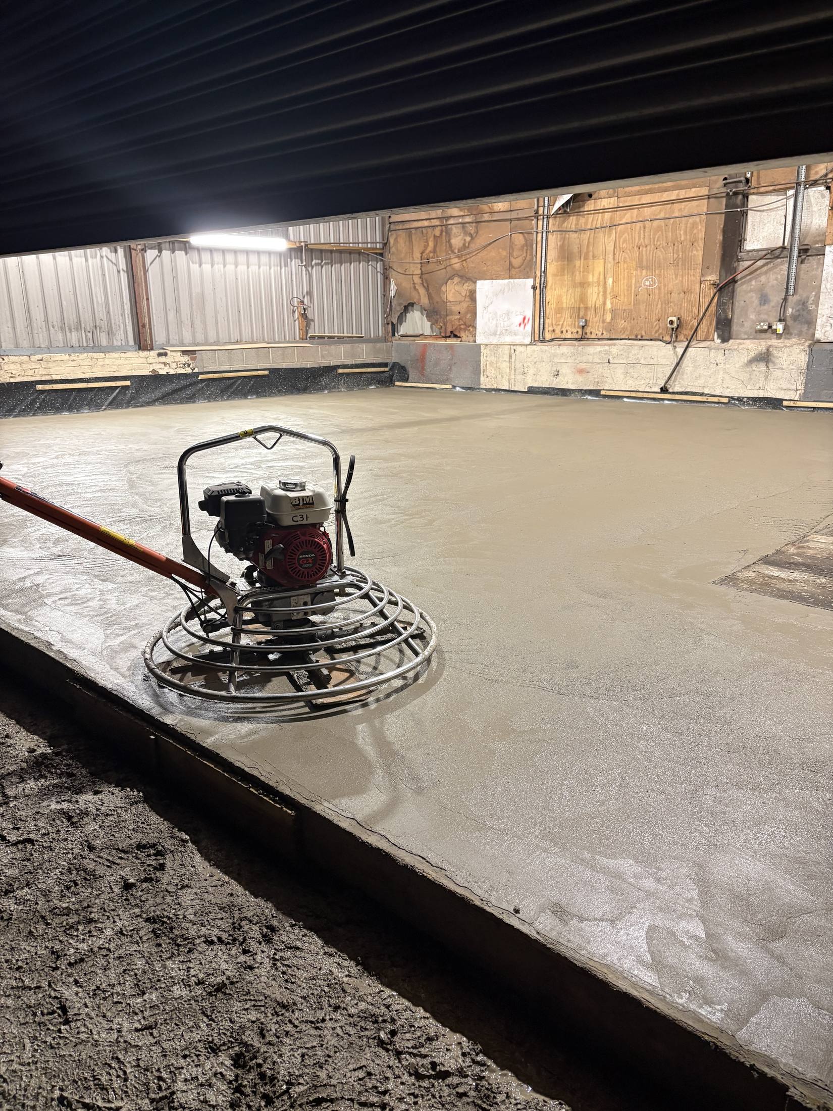 Power floating a concrete floor inside an agricultural building
