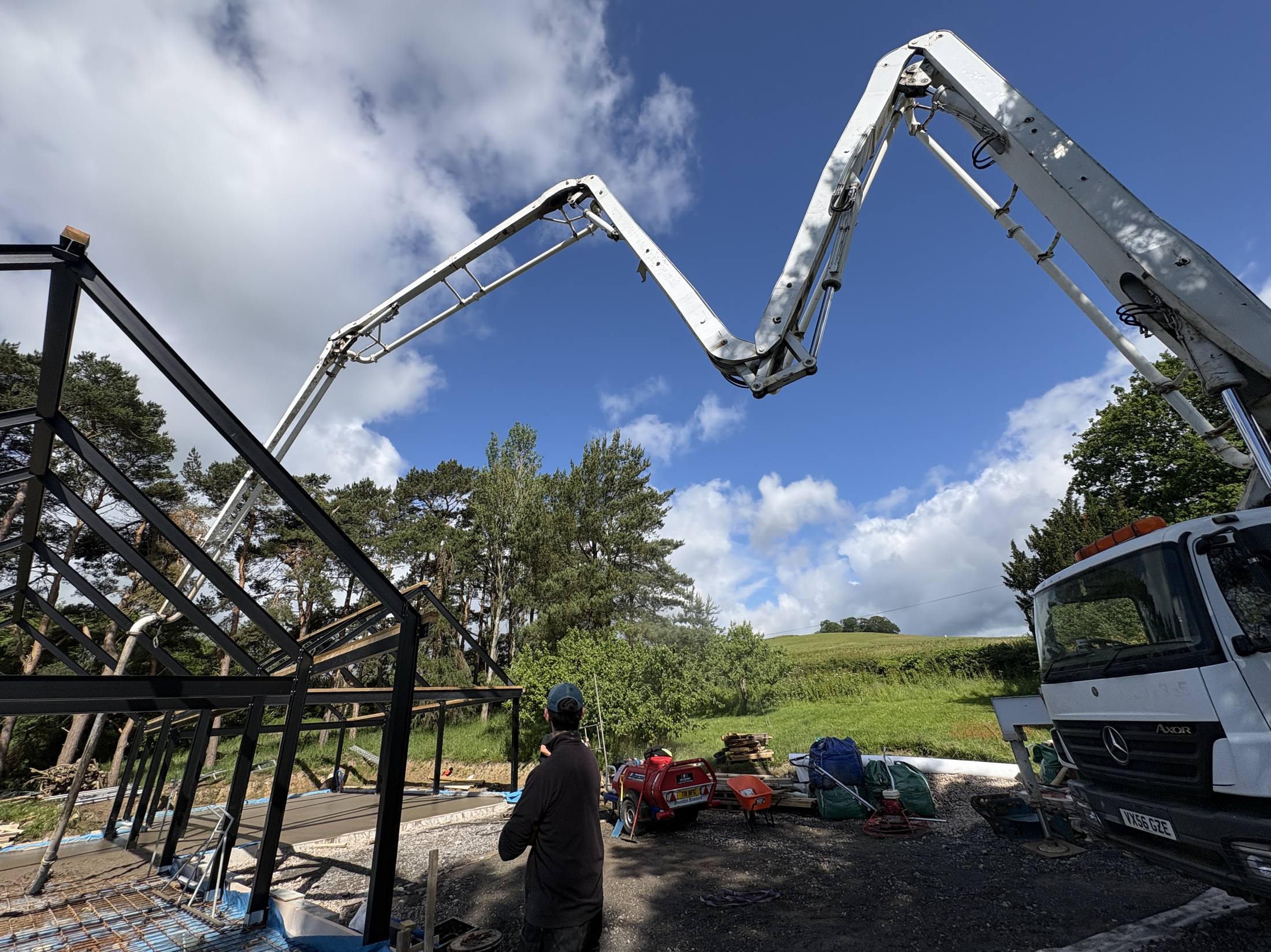Boom pump working alongside a steel frame building