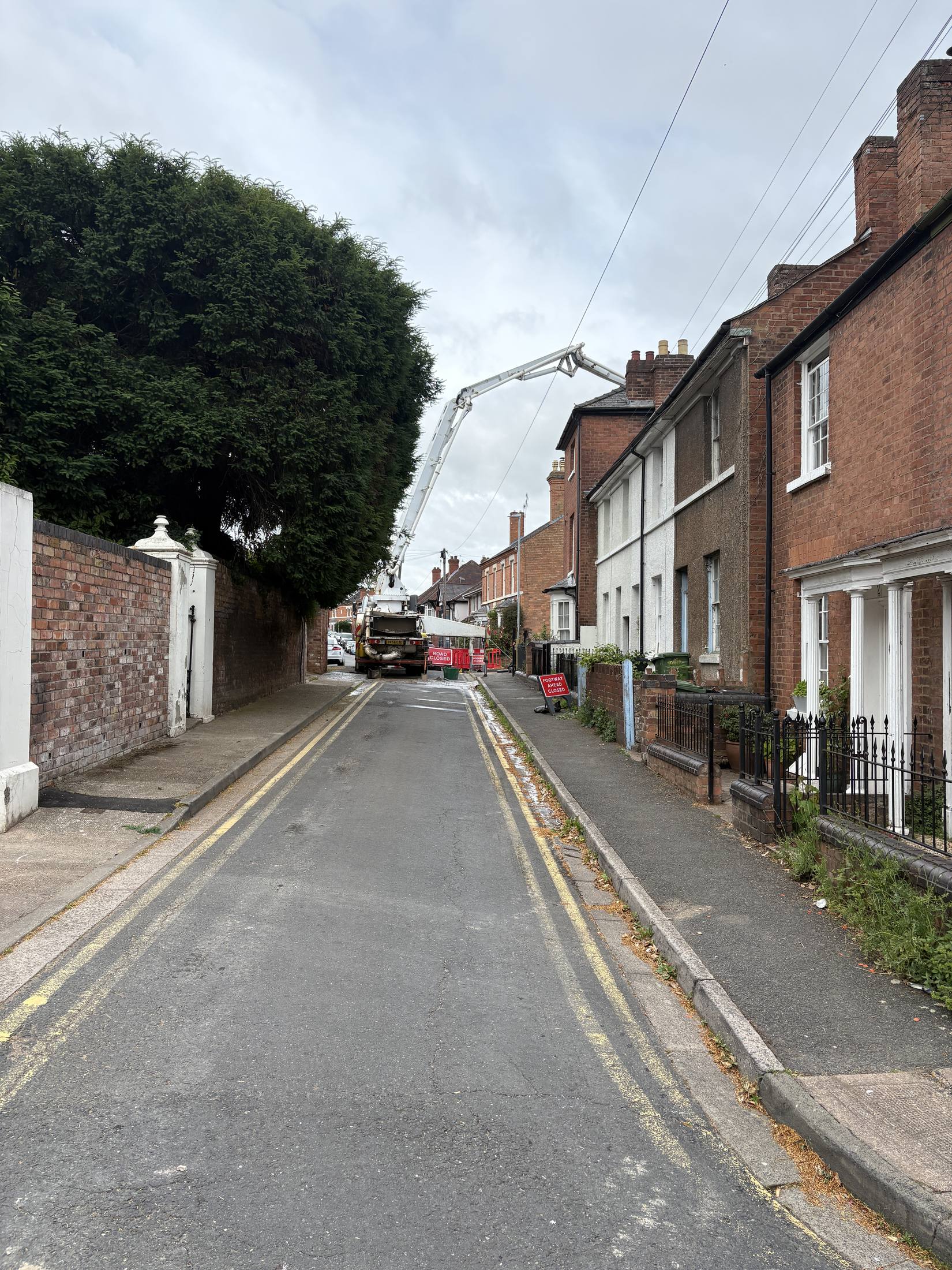Boom pump reaching over a tight residential street