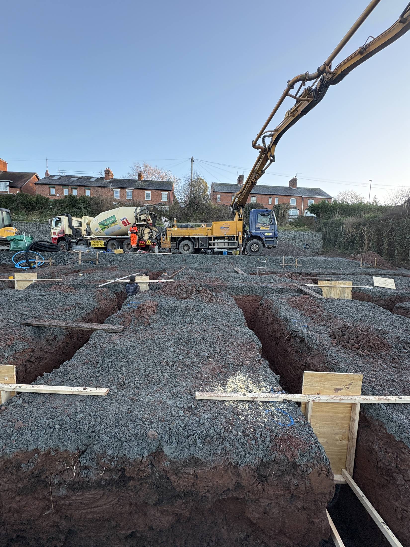 Boom pump working over foundation trenches