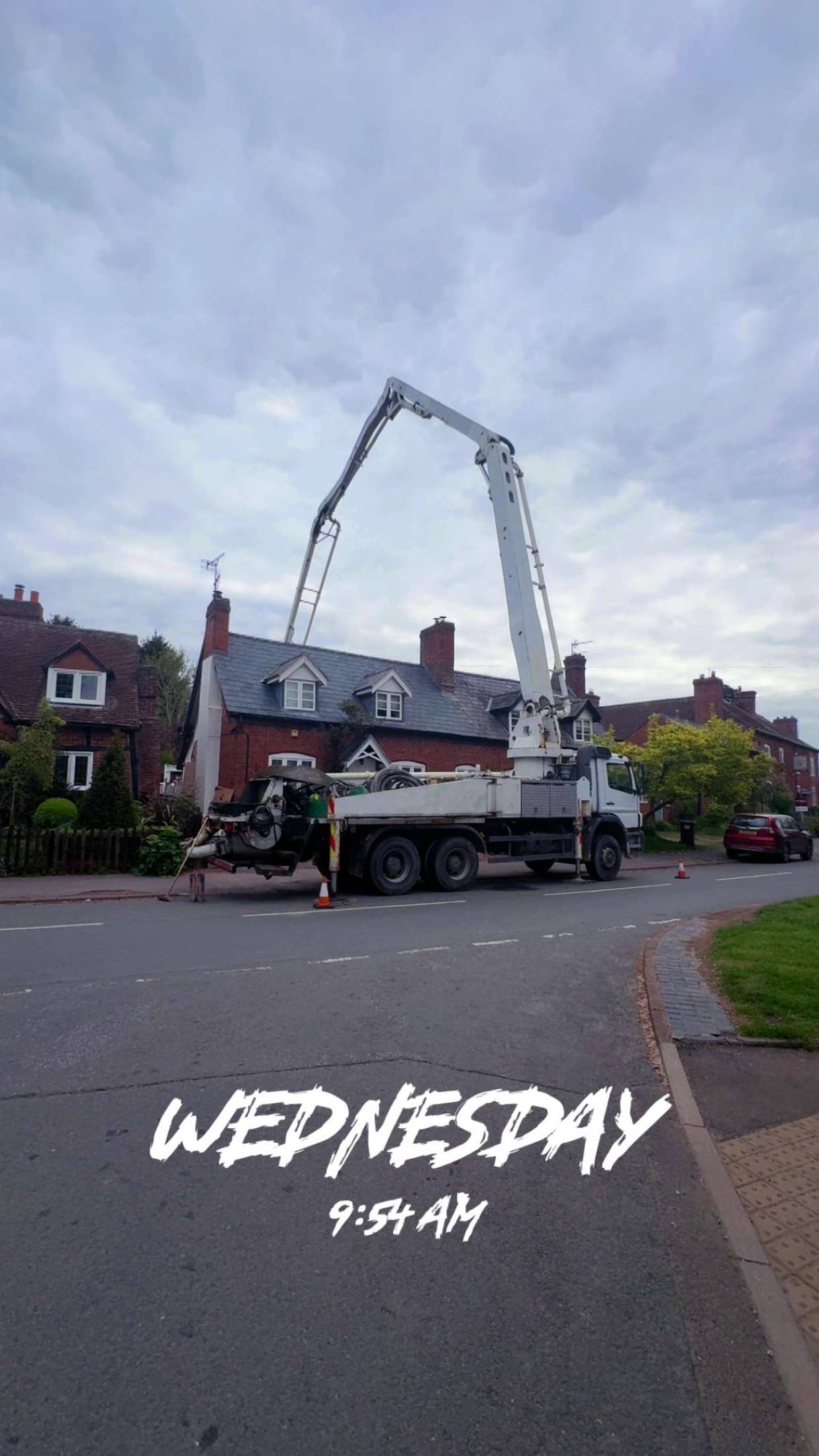 Concrete boom pump reaching over a residential street in Shropshire