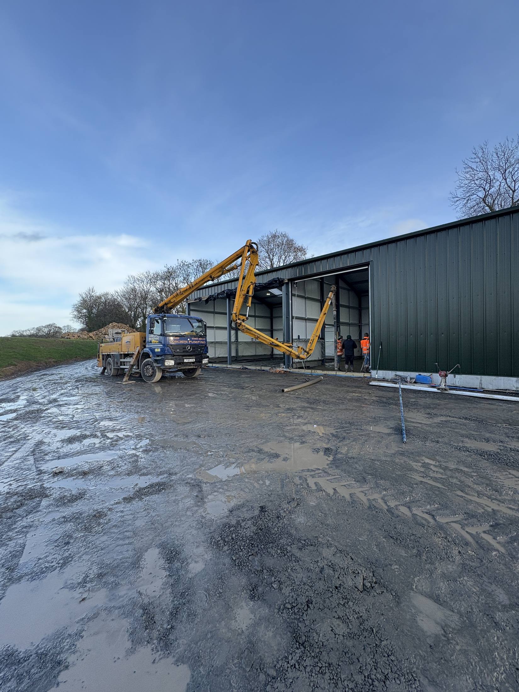 Concrete pump pouring inside an agricultural building