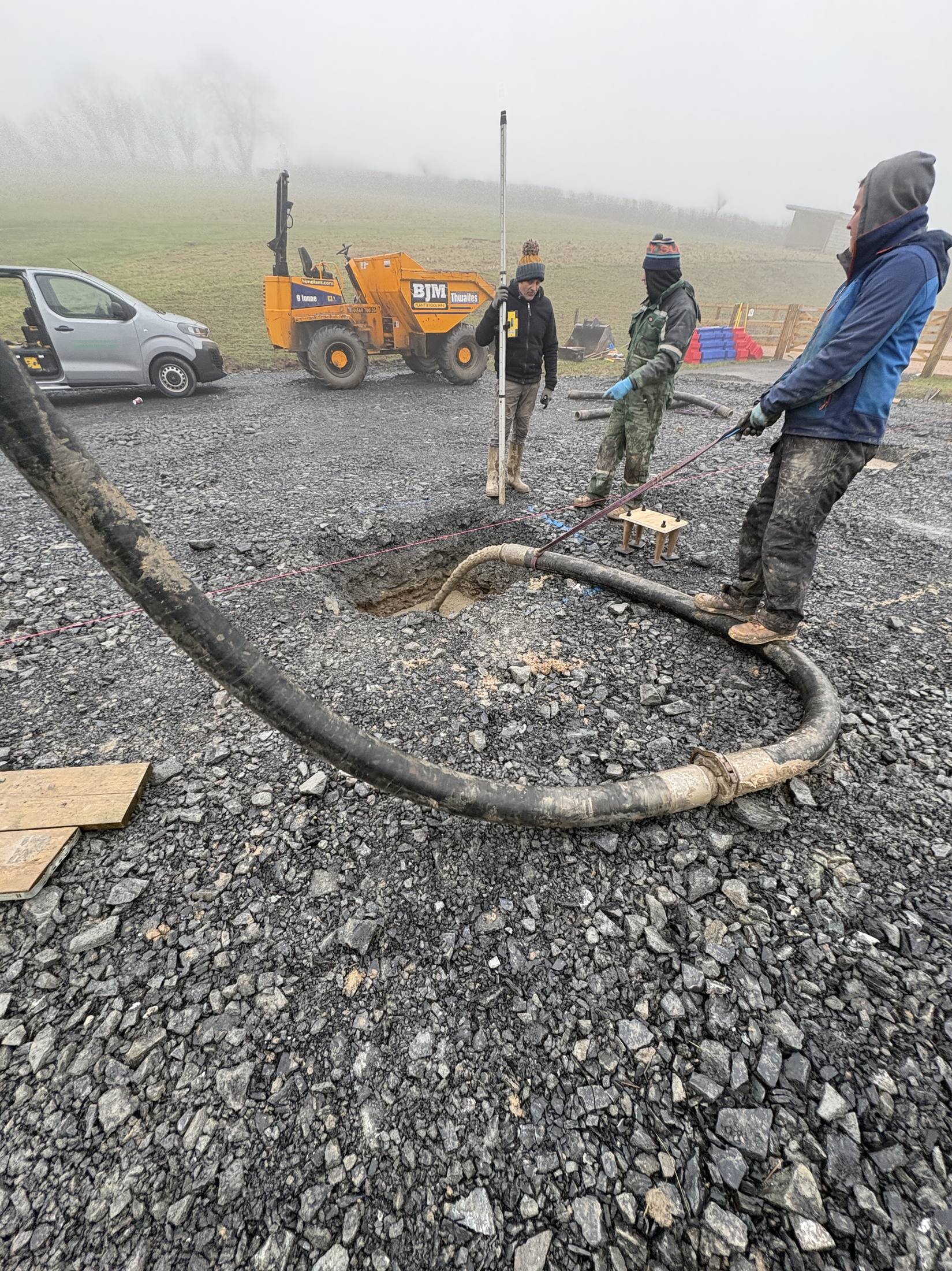 Line pump hose running across a site to a foundation hole