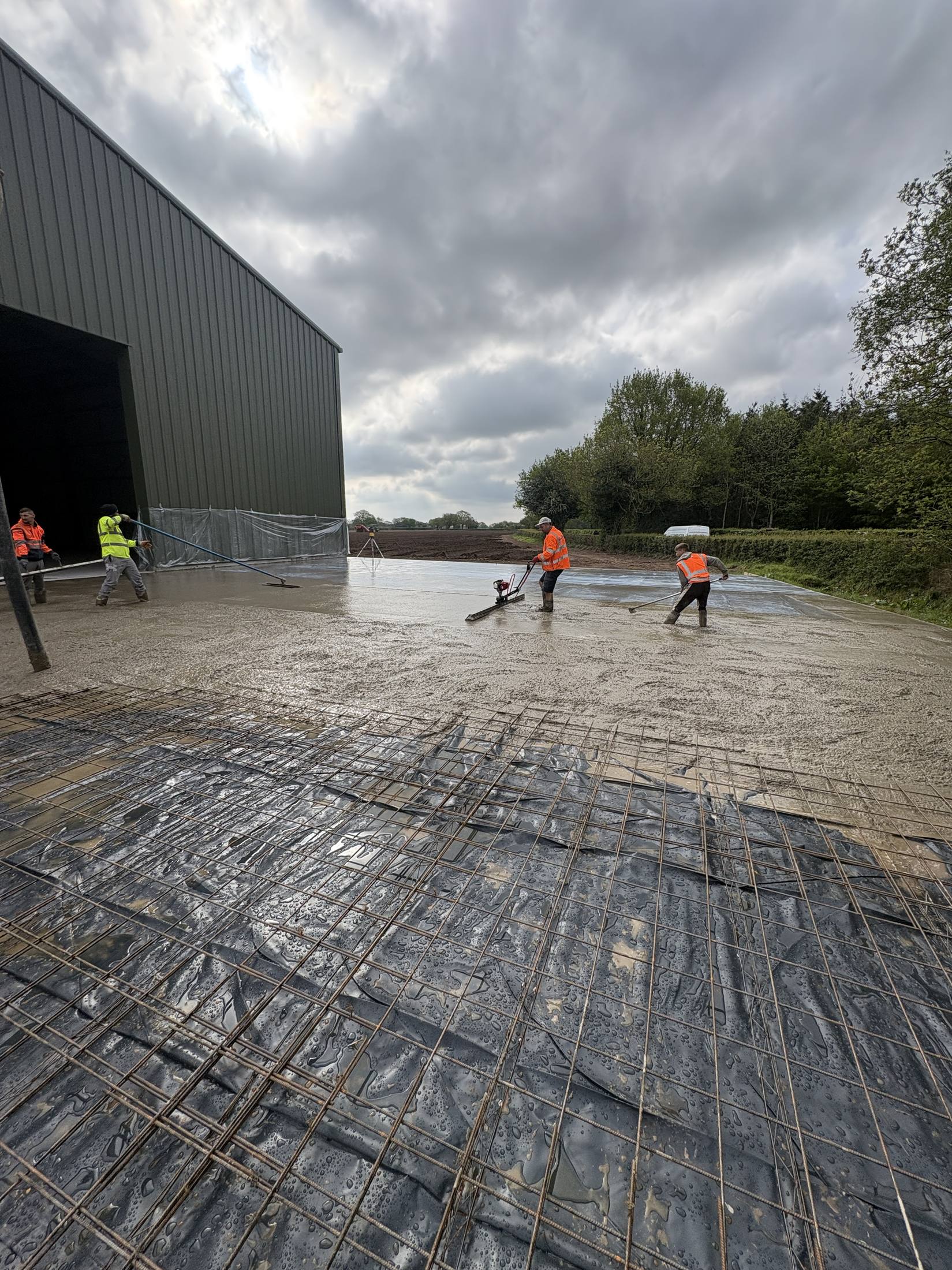 Line pump finishing a roof slab pour on scaffolding
