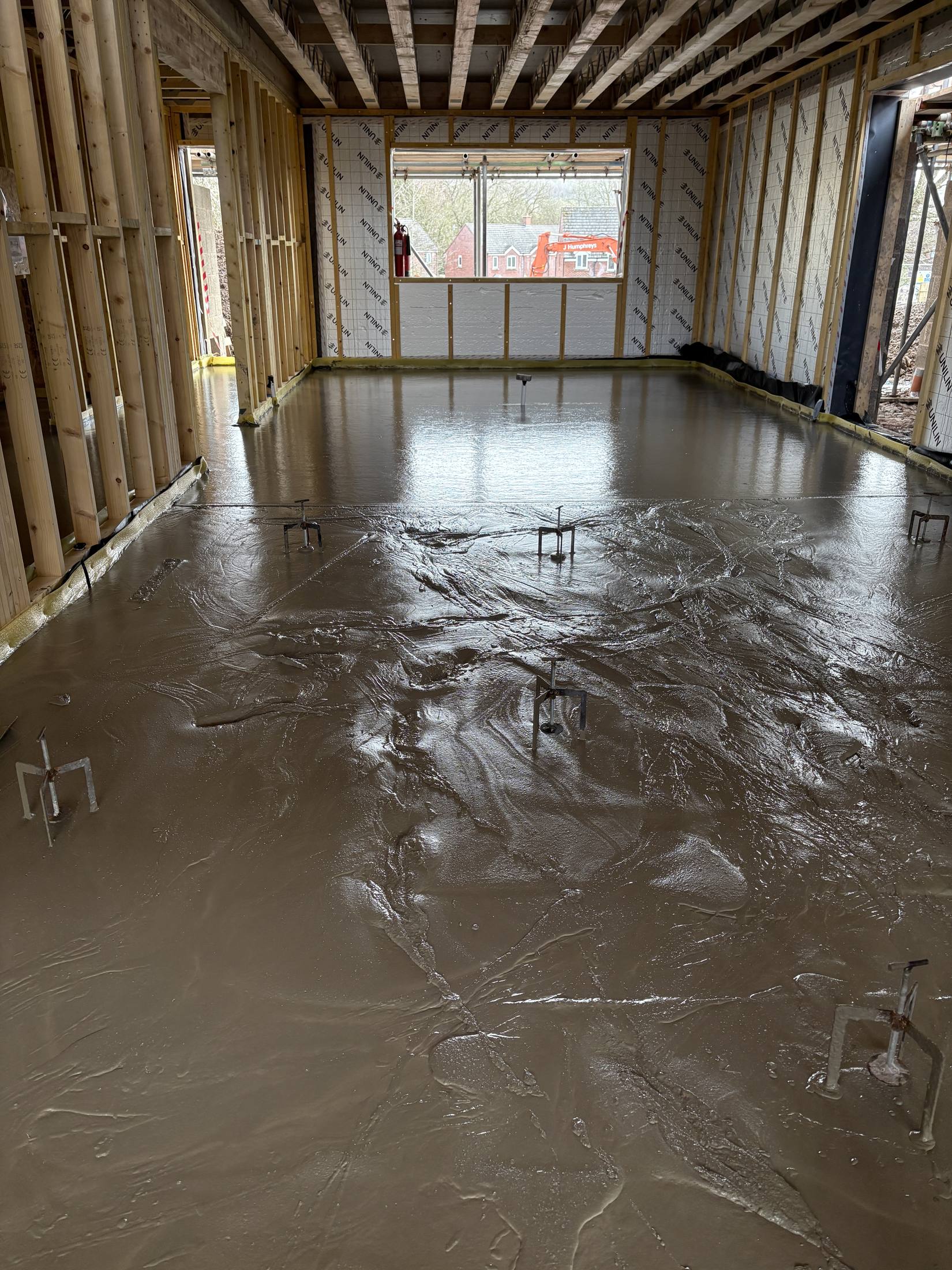 Liquid screed poured across a large new build room